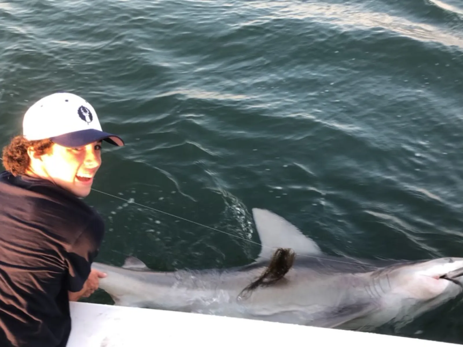 Captain beside a shark during a South Jersey shark fishing charter